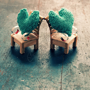 敬畏可爱的团结两颗心要在一起情侣像插图一样相爱照顾和护绿色心放在手工制作的迷你家具上作为椅子摇摆在木本底床上背景图片