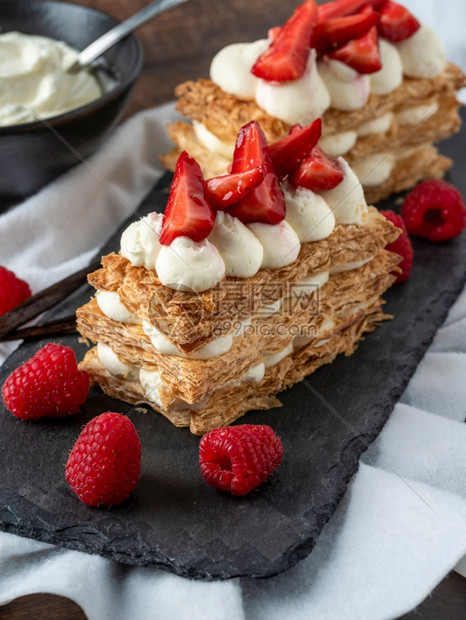 糖烘烤的拿破仑黑石板上的草莓和CreamMilleFeuille甜点在黑石板上贴有图片