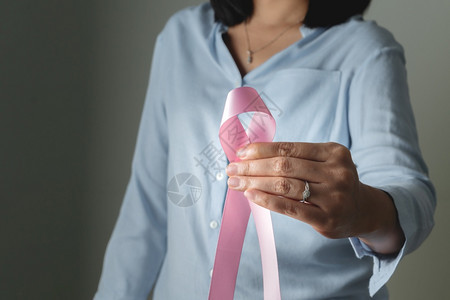 手拿粉色丝带预防乳腺癌概念图片