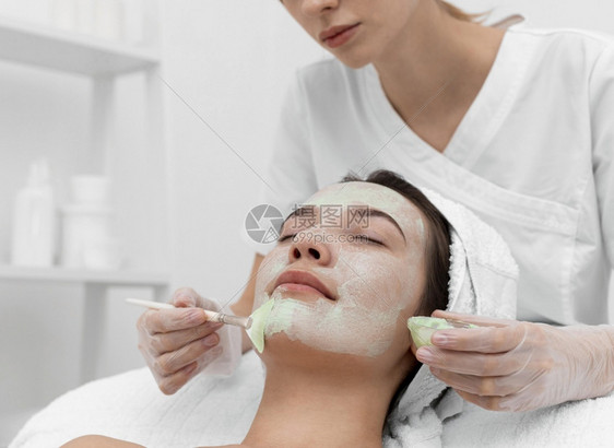 妇女美容院面部治疗按摩刷子在室内图片