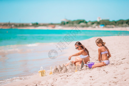 年轻美丽的母亲和可爱小女儿在热带沙滩玩得开心享受暑假的美丽母亲和女儿在沙滩上过着愉快的时光水育儿微笑图片