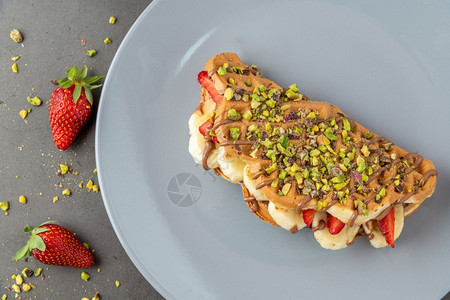 三明治新鲜的上面有香蕉草莓巧克力和活塞的松饼上面有香蕉草莓和巧克力比利时的图片