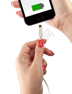 危险的电池互联网女人手中的智能机连接USB电缆充器在白色背景上隔离女人手中的智能机图片