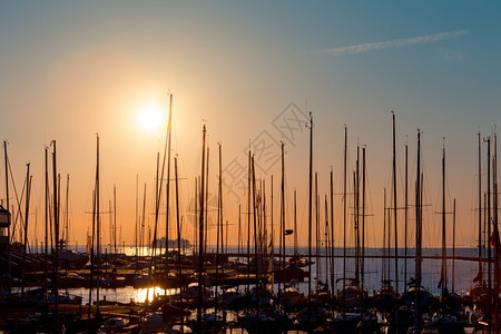 黎明航行晚上码头的渔船排行数与日落和黄昏照明旗帜图片