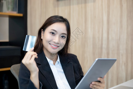 卡片支付在线使用平板和信卡购物方式的女亚洲人手女孩高清图片素材