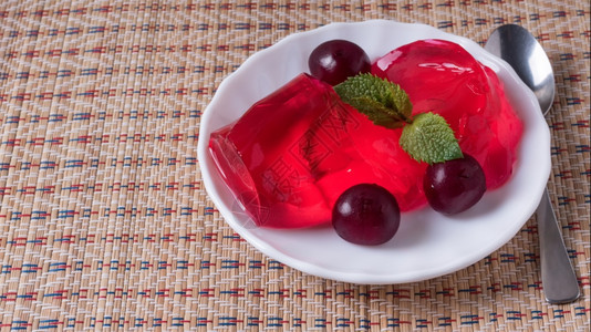 美味樱桃果和成熟的在旧蓝色桌上有叶子Jelly在白色盘子里有成熟樱桃浆果桌子健康图片