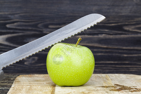绿色苹果用金属尖刀切成面包的绿色苹果阴影食物吃图片