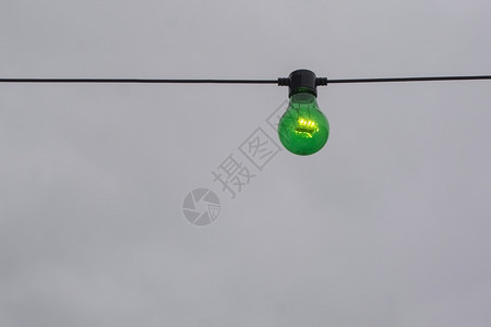 电现代的灰色天空背景字符串上绿色颜灯泡的绿亮电气图片