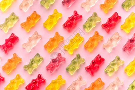 粉红背景的果冻熊和模式由美味果冻熊吃可口明亮的图片