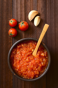 自然煮熟的乡村由新鲜番茄大蒜干红菜和盐制成的意大利自传统马里拿拉或pomodoro番茄酱在带有原料的生锈碗中供应用天然光选择焦点图片