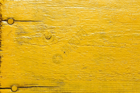 木头粗糙的外部涂漆黄色木桌用钉子作为纹理图片