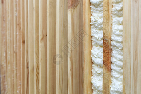 装修聚氨酯填补垂直木板与复制空间距之的白在模糊阴影中填补用建筑泡沫充垂直木板之间空白的一个实例柔软图片