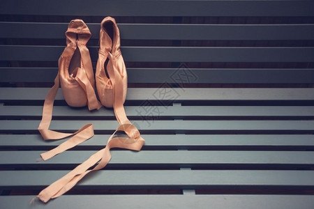 木制背景芭蕾舞女演员的足尖鞋粉色芭蕾舞木制背景芭蕾舞女演员的漂亮足尖鞋粉色芭蕾舞经典的类普安特图片