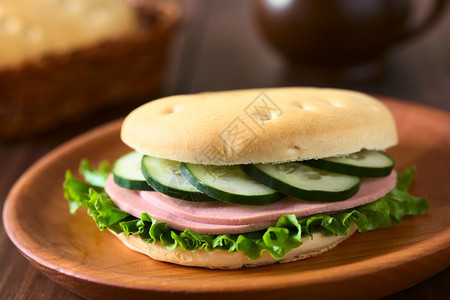智利传统的哈鲁拉面包卷作为三明治制成配有生菜冷切和黄瓜放在木板上用自然光拍照选择焦点集中到三明治的前面来着美国包子糕点图片