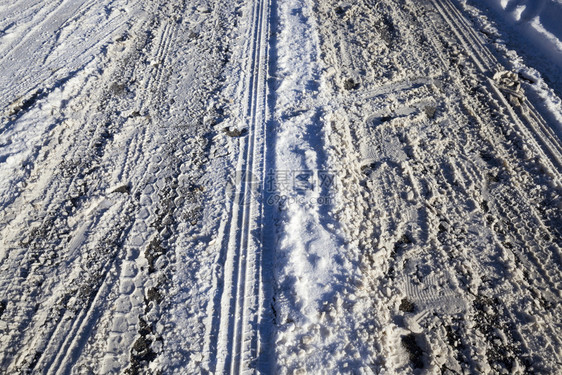 冬季公路包括许多车道和一条简洁紧凑的积雪覆盖不平坦的冬季公路阳光巷道车辆图片