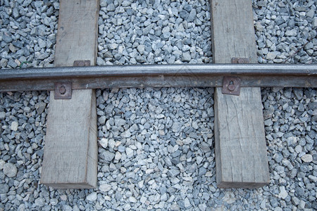 运输铁轨由钢制成放置在一块木头上石板地很小路图片