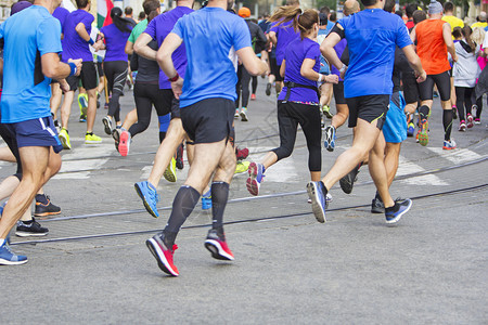 团体马拉松赛跑者在城市公路上奔跑运动的腿图片