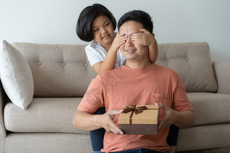 天爸这个亚洲家庭有一父亲和女儿一个小孩给父亲送一个生日礼物盒他们在家里幸福快乐的生日礼物盒带给父亲男图片