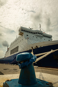 货运国际的海岸船弓和绳子被绑在Pier和Crane的BlueBollard图片