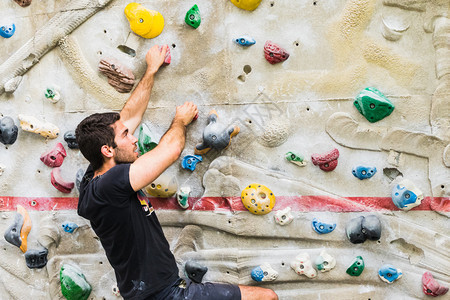 登山者运动抱石一个人在室内造墙壁上攀岩活生方式和巨石概念的形成图片