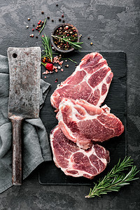 肩膀午餐木板黑石背景的生猪肉新鲜牛排顶视图片