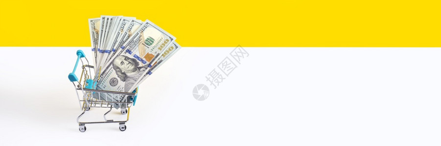 黄色的贸易玩具超市推车或购物满是黄色和白背景上的钱隔离货币贷款或销售概念长横幅带有复制空间现金图片