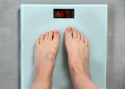 信息常设脚丫子数字体重秤上的脚带有单词FAT顶视图消息不健康的生活方式减肥消息帮助概念关闭数字体重秤上的脚帮助概念图片