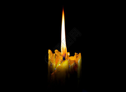 冥想温暖的祈祷在黑色背景上闪亮燃烧的灯光蜡烛图片