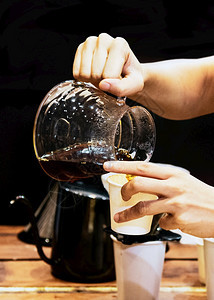 做咖啡的酒吧把倒在玻璃里的酒制作者豆滴图片