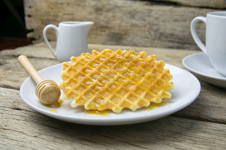 甜点带一杯咖啡和蜂蜜的松饼盘子烘烤图片
