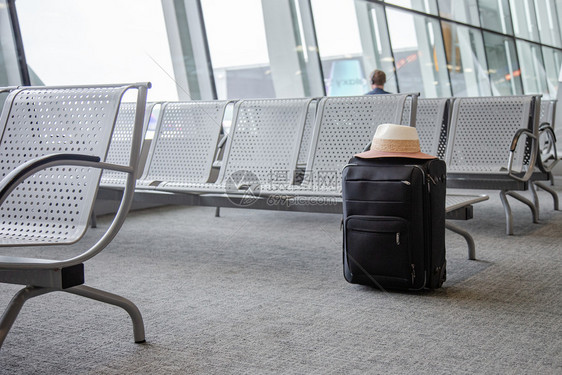 机场候区的手提箱丢失行李的概念机场候室的一个黑色手提箱机场候区的手提箱场候室的一个黑色手提箱旅游安全平台图片