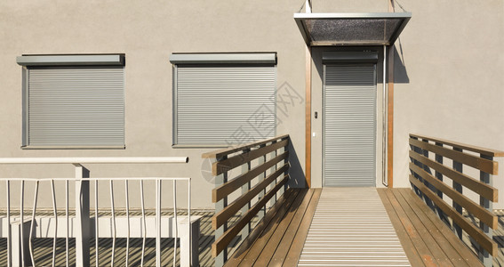 家有条纹的外部房屋门窗上的浅米色金属百叶窗房屋正面门上的金属百叶背景图片