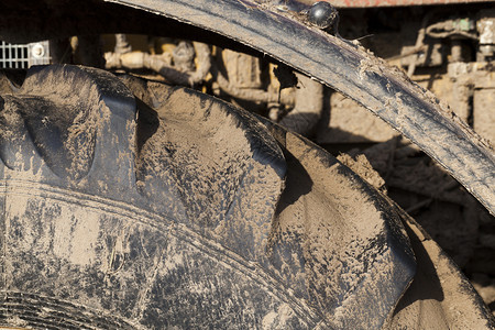 干燥土块拖拉机的橡胶轮在田地土壤中脏掉在为种植泥土轮式拖拉机而加工土壤期间被涂抹新的图片