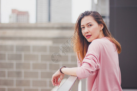 建造长发女人站在阳台上着红色的感图片