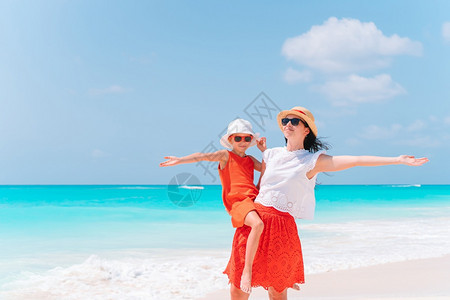 海滨年轻美丽的母亲和可爱小女儿在热带海滩玩得开心在加勒比海滩享受暑假的美丽母亲和女儿在加勒比海滩过着愉快的时光微笑女图片