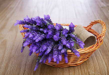 花朵自然乡村的在旧木制桌边篮子里放着一捆熏衣草花图片