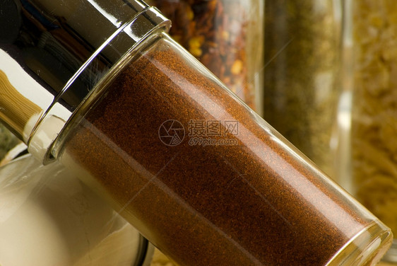 罐子木制垫上玻璃罐中的不同香料草药辣椒图片