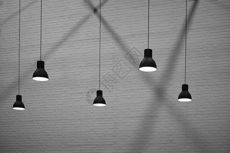 黑色的绞刑侧视图和有选择地聚焦5个挂着灯的具在黑白风格砖墙底色和白壁布面上闪光和影子内部建筑设计概念复古的图片