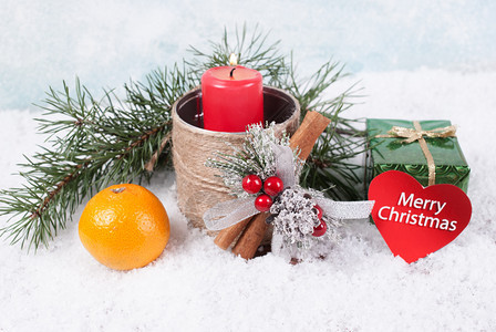 假期红蜡烛礼品盒橘子和雪地背景的圆木枝印有贺卡圣诞节礼物图片