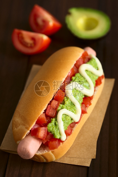 由面包香肠番茄鳄梨和蛋黄酱制成的意大利传统热狗三明治在黑木上用天然光拍攝选择焦点聚点三分之一放在热狗上黑暗的拍照第三图片