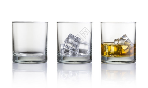 空玻璃装有冰块的玻璃和配有威士忌冰块的玻璃在白色背景上隔离流动的派对饮料图片