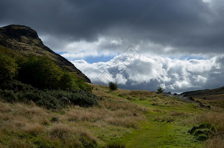 旅游峭壁结石苏格兰Arthirrsquos座位上方云多的天空图片