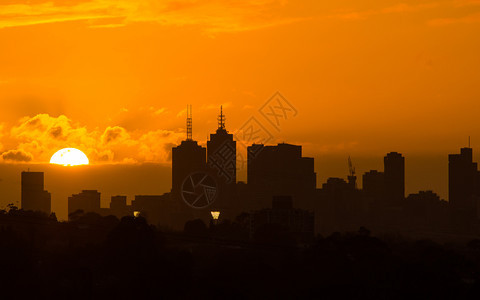 城市墨尔本天际之后的金色大太阳落下商业光图片