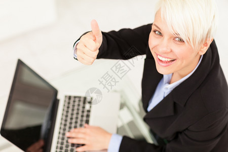 商业女人在办公室微笑的同时作出积极的拇指手势女孩网络白种人图片