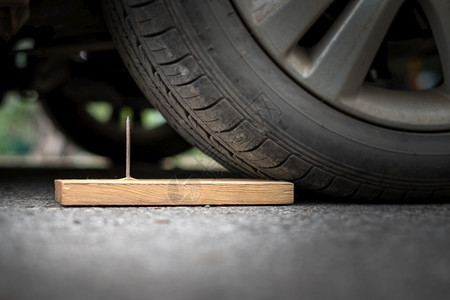 车轮汽把木板上的铁钉紧贴在木头上几乎穿入轮胎洞图片