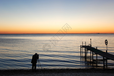 沿海在浴池码头旁拍摄日落的男子月光海洋摄影师图片