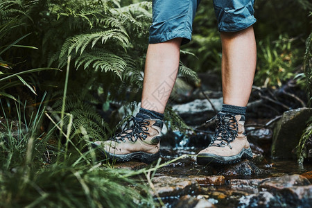 登山靴的女腿站在山间溪流的石头上暑假接近自然积极度过休闲时光的概念健康运动周末图片