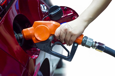 气体活力旅行手持泵喷嘴正在向一辆红色汽车的油箱加图片