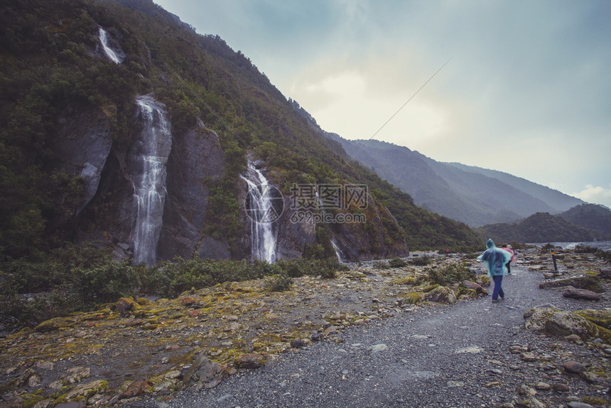 旅行雨高山游者在大雾中漫步前往franzJosef冰川图片