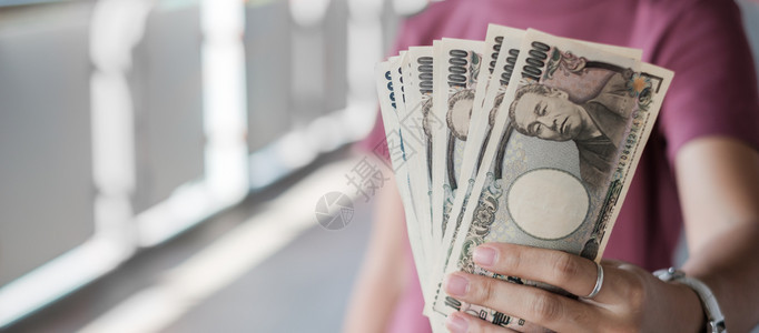 持有日币钞票货投资金融和支付概念的女商人手持日元纸币堆叠商业金融和付款概念女钱银行业图片